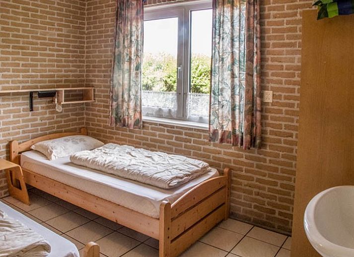 Gezellige woonkamer van De kemphaan: Vakantiehuis Texel in De Koog, met comfortabele zitruimte en houtkachel.