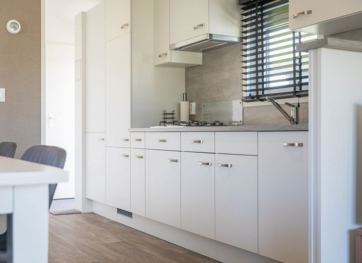 Chaletpark Bregkoog - Chalet Bregkoog 262 in De Koog, Texel, een modern vakantiehuis met houten terras en omheining.