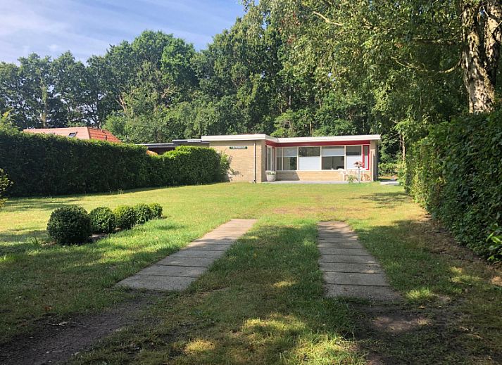 't Buitenhuisje in De Koog, Texel biedt een moderne woonkamer met comfortabele stoelen en een gezellige sfeer in dit vakantiehuis.