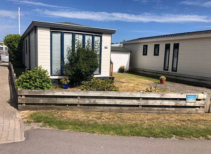 Chaletpark Bregkoog - Chalet Bregkoog 33 in De Koog, Texel met charmante tuin en houten hek, ideaal voor een ontspannen vakantie.