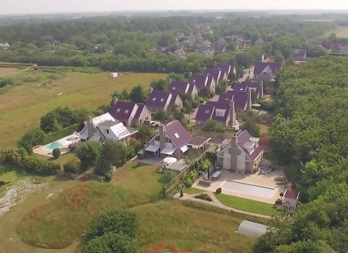 Waddenstaete 5 Pers. Ferienhaus in De Koog, Texel mit gruenem Garten und roten Dachziegeln.