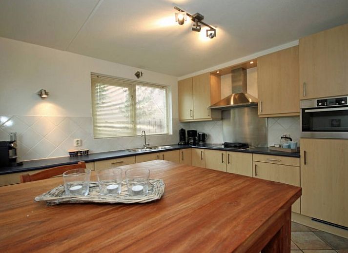 Waddenstaete 5 Pers. Ferienhaus in De Koog, Texel mit gruenem Garten und roten Dachziegeln.