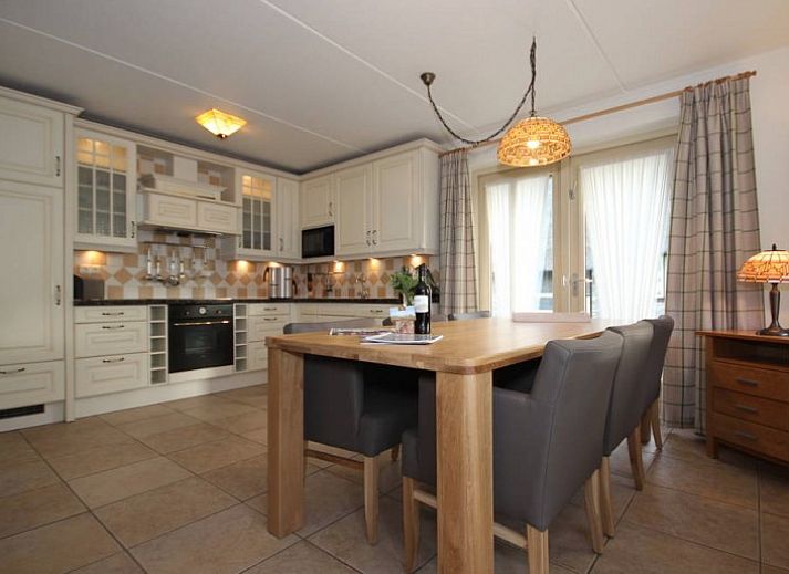 6 Person luxury villa with sauna in De Koog, Texel, surrounded by green nature and terrace with parasol.