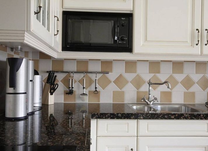 6 Person luxury villa with sauna in De Koog, Texel, surrounded by green nature and terrace with parasol.