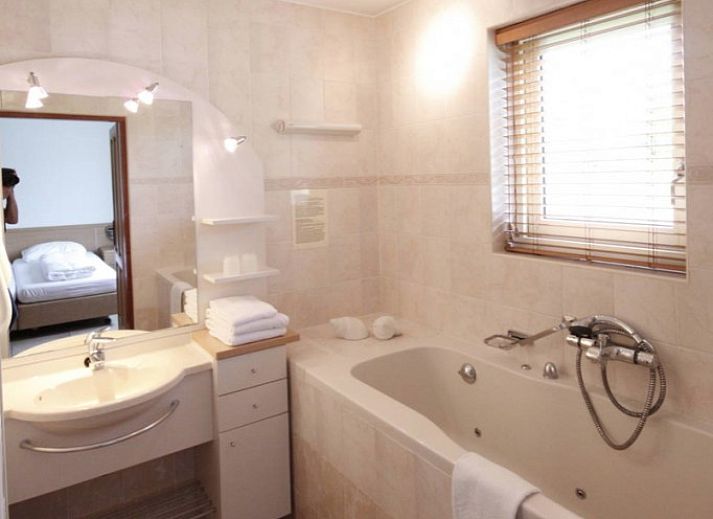 6 Person luxury villa with sauna in De Koog, Texel, surrounded by green nature and terrace with parasol.