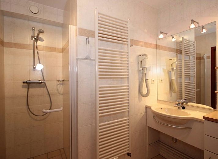 Gezellige woonkamer in 6 Persoons luxe villa met sauna, De Koog, Texel, met open haard en comfortabele zitplaatsen.