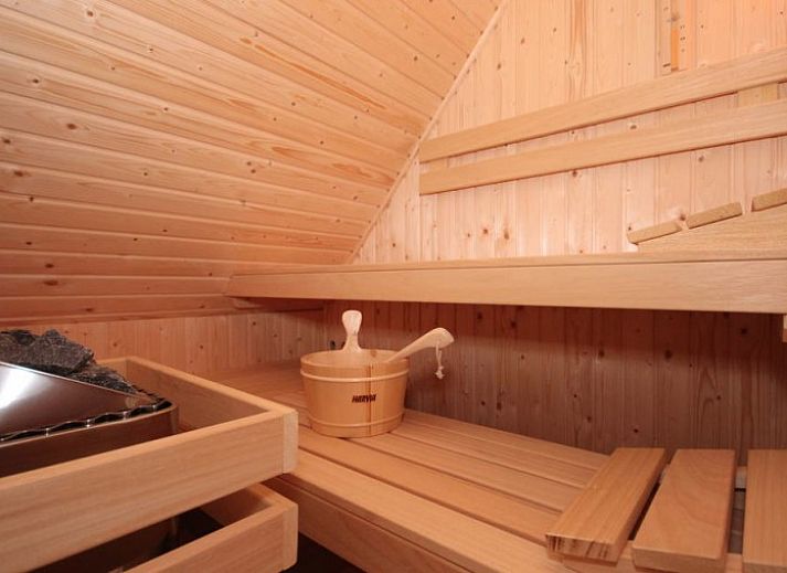 Gezellige woonkamer in 6 Persoons luxe villa met sauna, De Koog, Texel, met open haard en comfortabele zitplaatsen.