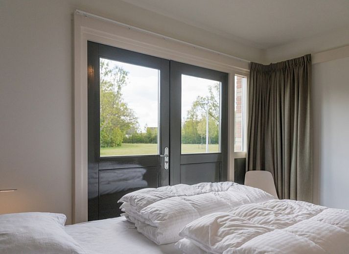 Gezellige woonkamer in Orchismient 24, De Koog, Texel met comfortabele zithoek en uitzicht op de tuin.