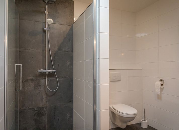 Gezellige woonkamer in Orchismient 24, De Koog, Texel met comfortabele zithoek en uitzicht op de tuin.