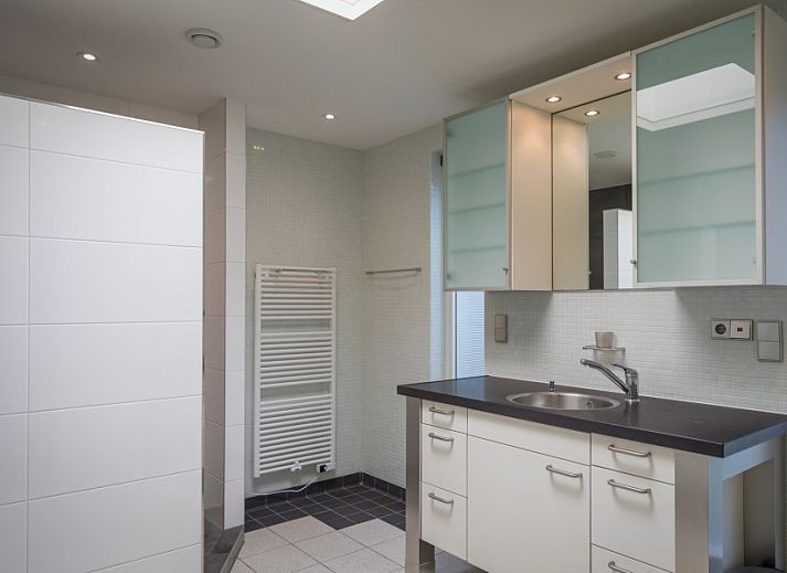 Gezellige woonkamer in Orchismient 24, De Koog, Texel met comfortabele zithoek en uitzicht op de tuin.