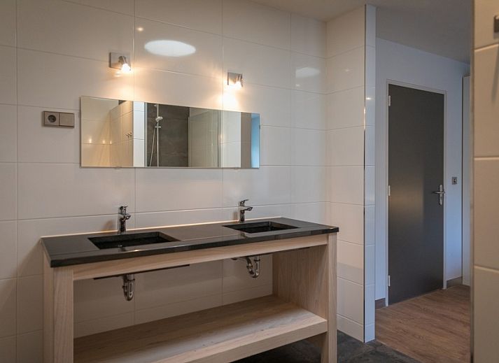 Gezellige woonkamer in Orchismient 24, De Koog, Texel met comfortabele zithoek en uitzicht op de tuin.