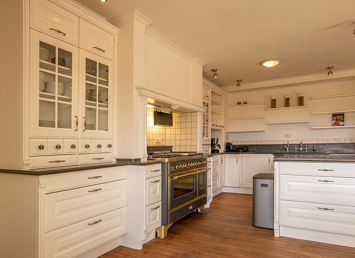 Bright living room of Kamerstraat 66 vacation home in De Koog Texel with glass roof and comfortable seating area.