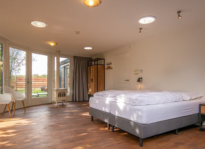 Bright living room of Kamerstraat 66 vacation home in De Koog Texel with glass roof and comfortable seating area.