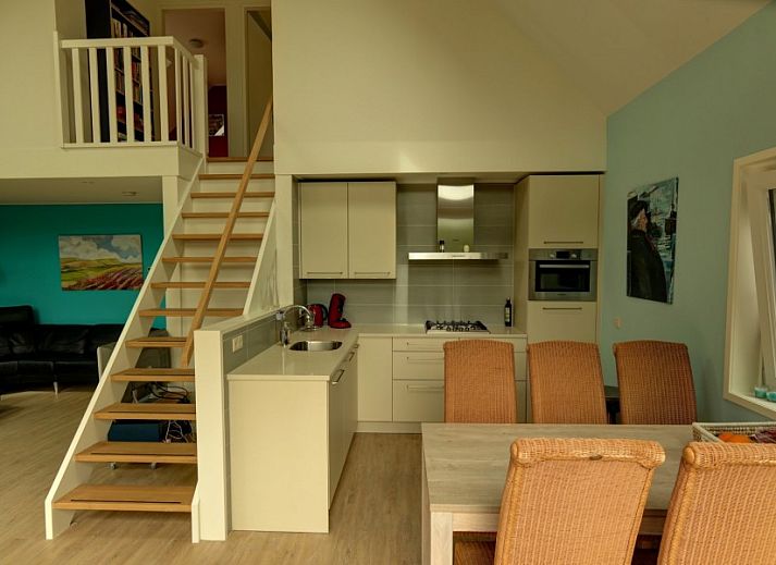 Ferienhaus Pelikaanweg 37 in De Koog, Texel mit einer einladenden Terrasse und natuerlicher Umgebung.