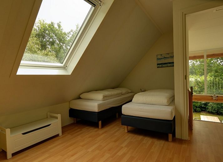 Ferienhaus Pelikaanweg 37 in De Koog, Texel mit einer einladenden Terrasse und natuerlicher Umgebung.