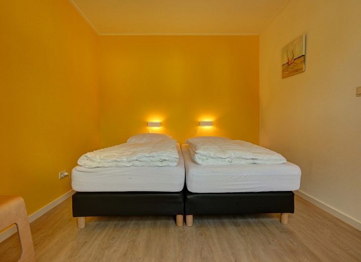 Ferienhaus Pelikaanweg 37 in De Koog, Texel mit einer einladenden Terrasse und natuerlicher Umgebung.