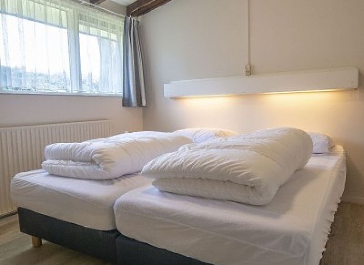 Vooraanzicht van vakantiehuis Californieweg 142 in De Koog, Texel, omgeven door groen en rust op de Waddeneilanden.