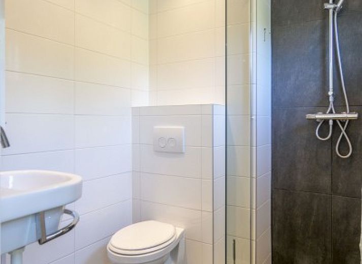 Vooraanzicht van vakantiehuis Californieweg 142 in De Koog, Texel, omgeven door groen en rust op de Waddeneilanden.