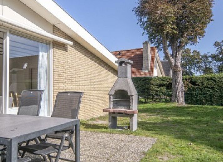 Gezellige binnenruimte van vakantiehuis Californieweg 142 in De Koog, Texel, met comfortabele zithoek en tuinzicht.
