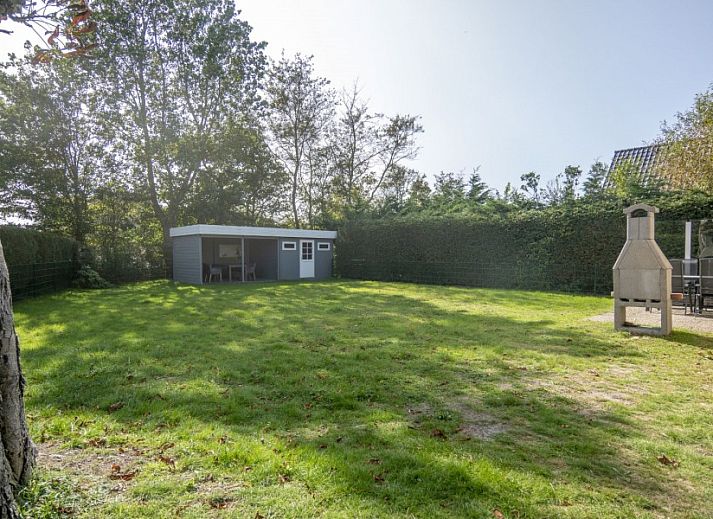 Gezellige binnenruimte van vakantiehuis Californieweg 142 in De Koog, Texel, met comfortabele zithoek en tuinzicht.