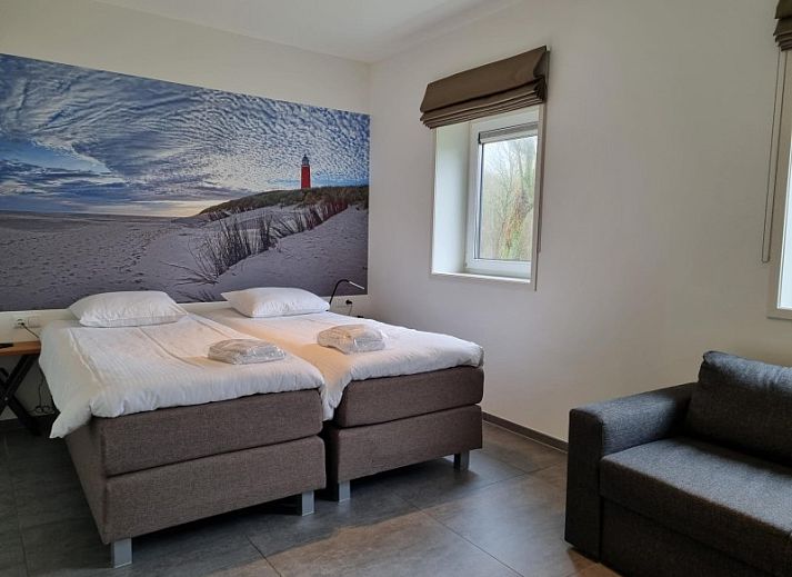 Moderne keuken in Villa Duyncoogh, een vakantiehuis in De Koog, Texel, met houten elementen en een uitnodigende bar op de Waddeneilanden.