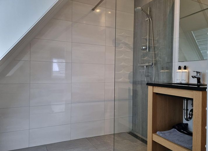 Moderne keuken in Villa Duyncoogh, een vakantiehuis in De Koog, Texel, met houten elementen en een uitnodigende bar op de Waddeneilanden.