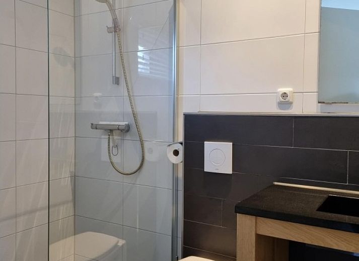 Moderne keuken in Villa Duyncoogh, een vakantiehuis in De Koog, Texel, met houten elementen en een uitnodigende bar op de Waddeneilanden.