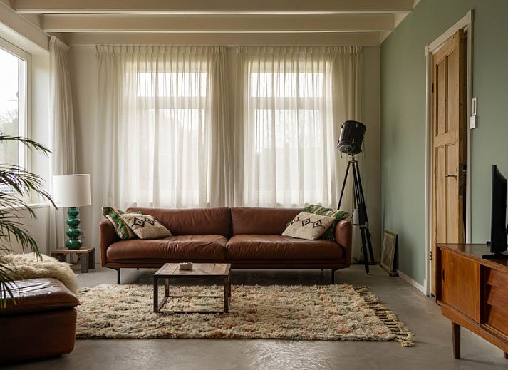 Gezellige zithoek met houtkachel in vakantiehuis Paal 234, De Koog, Texel, Waddeneilanden.