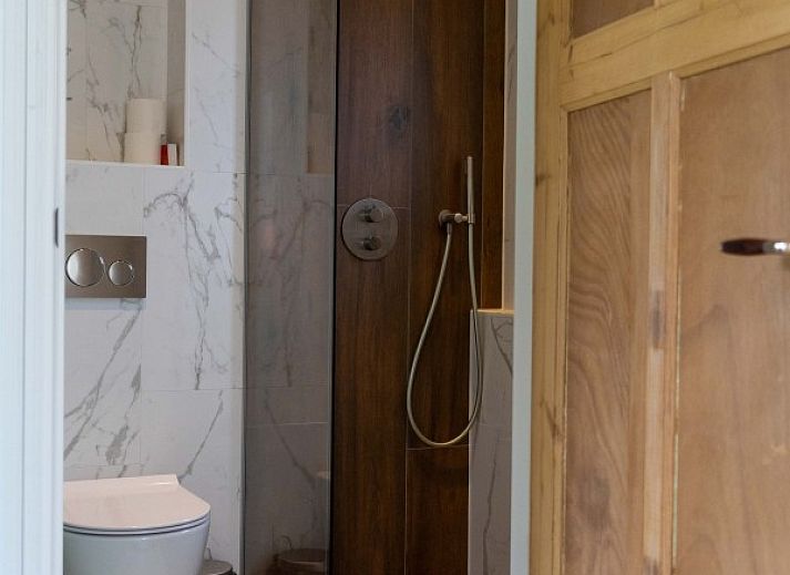 Buitenzijde van vakantiehuis Paal 234 in De Koog, Texel, omgeven door groene natuur.