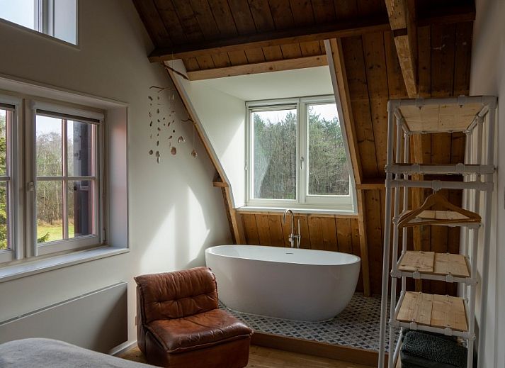 Stijlvolle woonkamer van Paal 234, een vakantiehuis in De Koog, Texel, met leren bank en vintage decor.