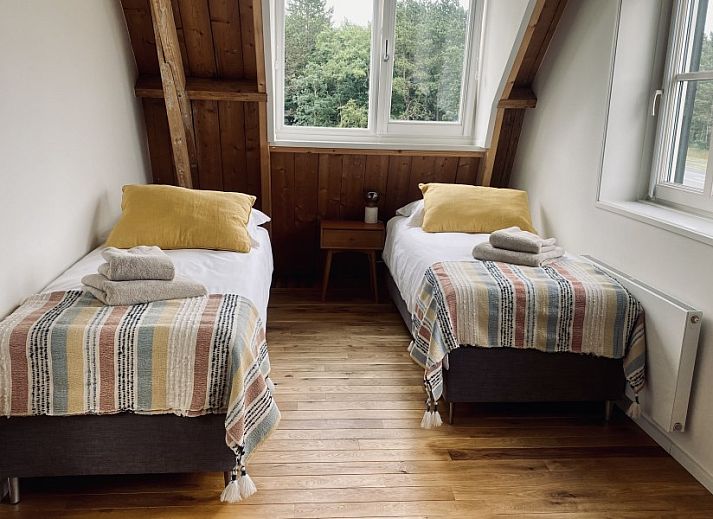 Stijlvolle woonkamer van Paal 234, een vakantiehuis in De Koog, Texel, met leren bank en vintage decor.