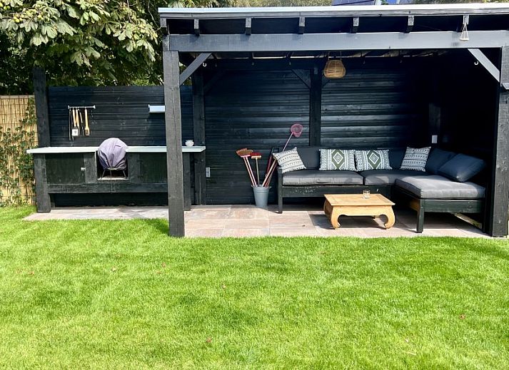 Lichte leefruimte in vakantiehuis Paal 234, De Koog, Texel, met comfortabele stoelen en grote ramen.