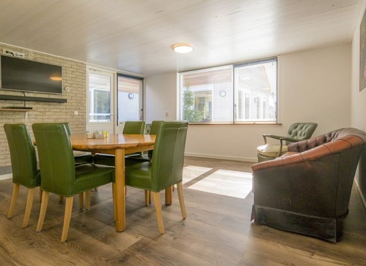 Cozy living room in Orchismient 51, vacation home De Koog, Texel with dining area and lots of natural light on the Wadden Islands.