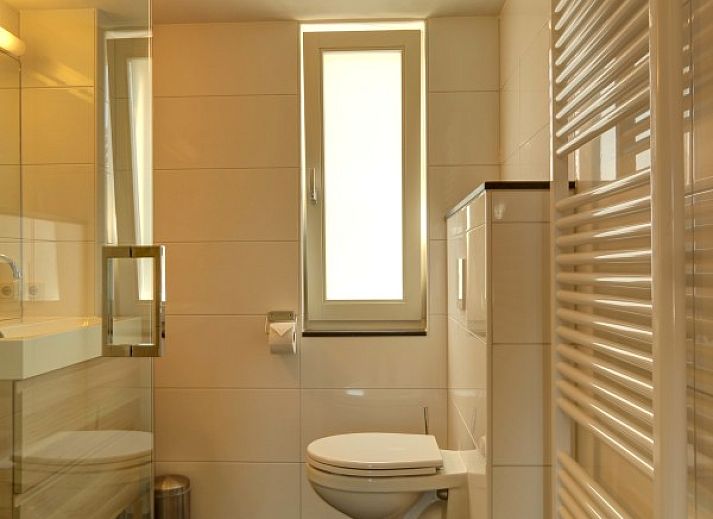 Ruime woonkamer van vakantiehuis Zusje van 17 in De Koog, Texel met veel licht en uitzicht op de tuin.