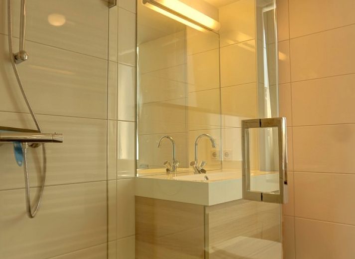 Ruime woonkamer van vakantiehuis Zusje van 17 in De Koog, Texel met veel licht en uitzicht op de tuin.