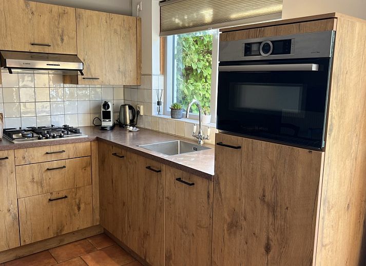 Gezellige woonkamer van Koetshuis vakantiehuis in De Koog, Texel met comfortabele banken en uitzicht op de natuur van de Waddeneilanden.