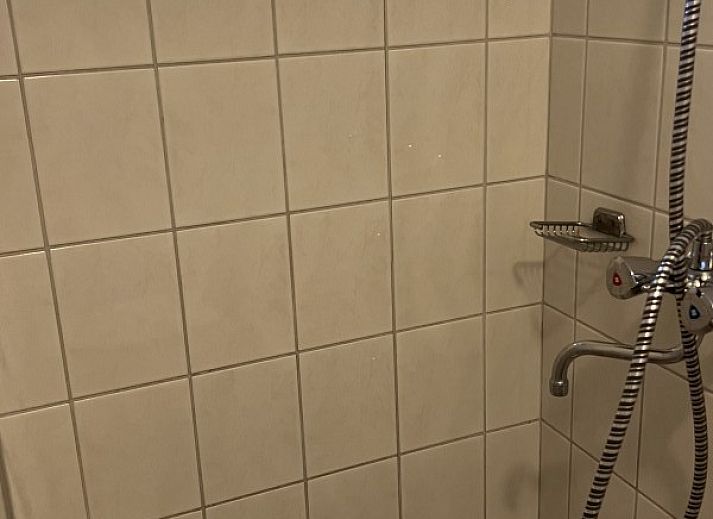 Gezellige woonkamer van Koetshuis vakantiehuis in De Koog, Texel met comfortabele banken en uitzicht op de natuur van de Waddeneilanden.