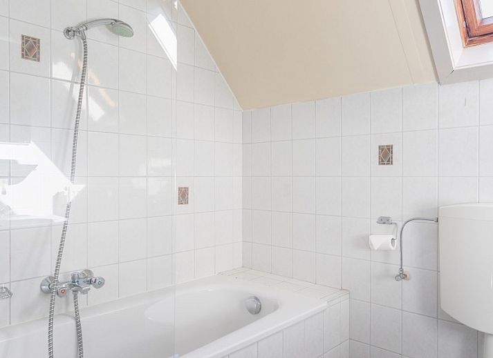 Gezellige woonkamer van Koetshuis vakantiehuis in De Koog, Texel met comfortabele banken en rustieke inrichting voor een ontspannen verblijf.