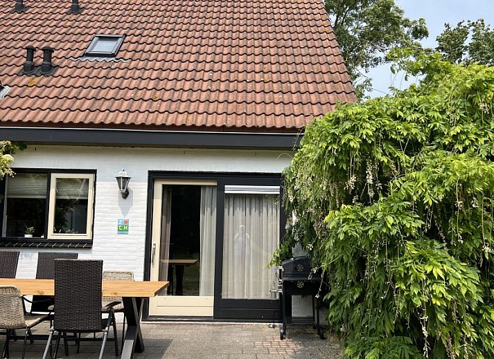 Gezellige woonkamer in Koetshuis vakantiehuis, De Koog Texel, met comfortabele zithoek en rustieke inrichting op de Waddeneilanden.