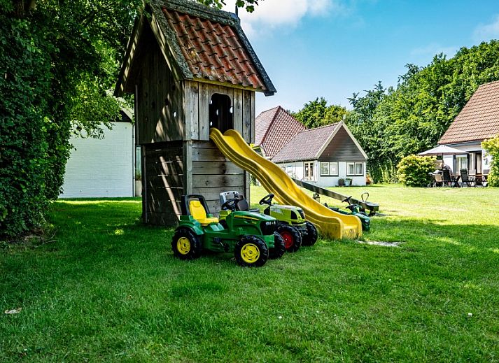 Moderne keuken in Koetshuis vakantiehuis, De Koog, Texel met houten kasten en uitzicht op groene natuur.
