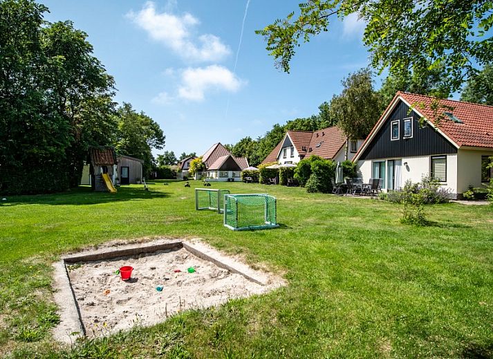 Moderne keuken in Koetshuis vakantiehuis, De Koog, Texel met houten kasten en uitzicht op groene natuur.