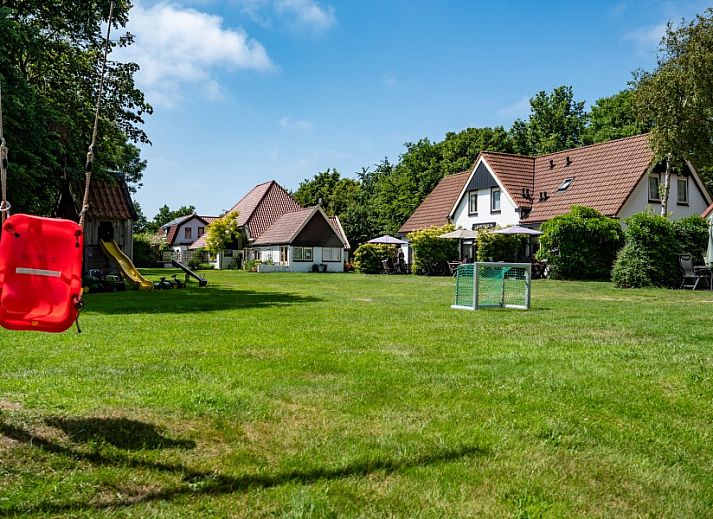 Moderne keuken in Koetshuis vakantiehuis, De Koog, Texel met houten kasten en uitzicht op groene natuur.