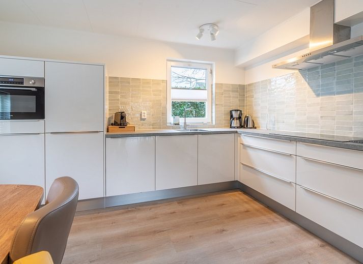 Terrasse und gruene Umgebung im Ferienhaus Honeysuckle 33 in De Koog, Texel.