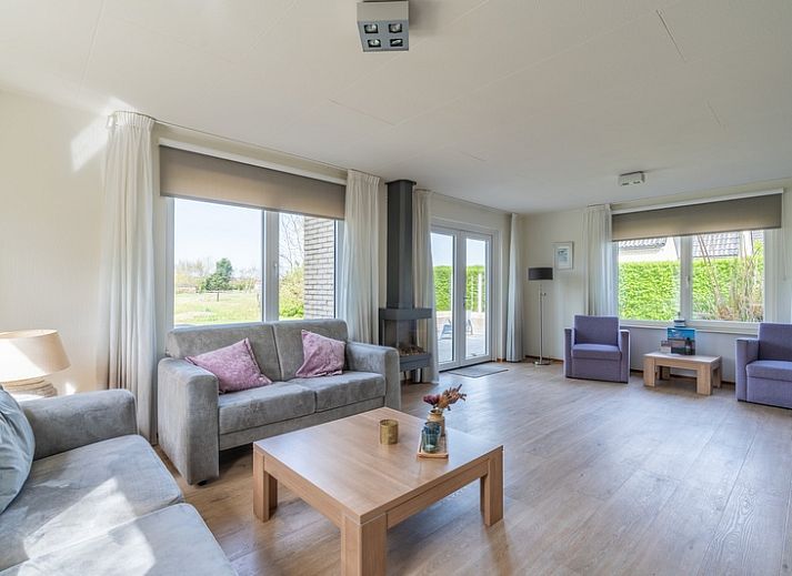 Buitenkant van Vakantiehuis Kamperfoelie 63 in De Koog, Texel, omgeven door groen.