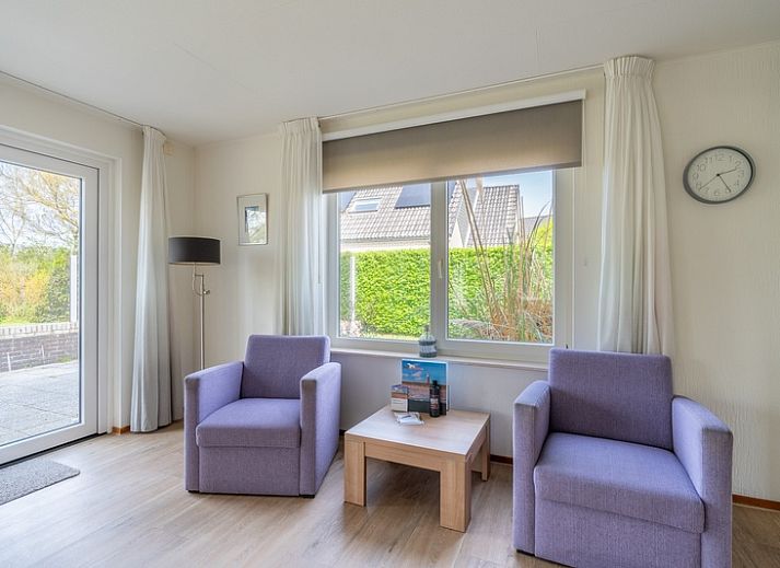 Buitenkant van Vakantiehuis Kamperfoelie 63 in De Koog, Texel, omgeven door groen.