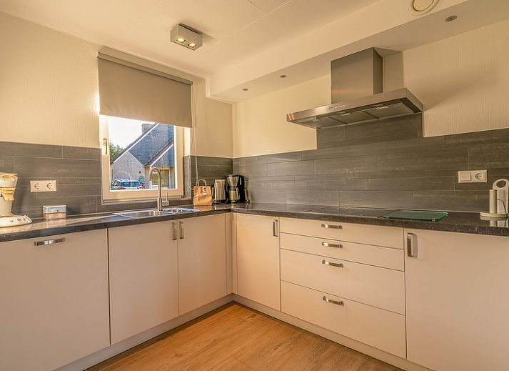 Buitenkant van Vakantiehuis Kamperfoelie 63 in De Koog, Texel, omgeven door groen.