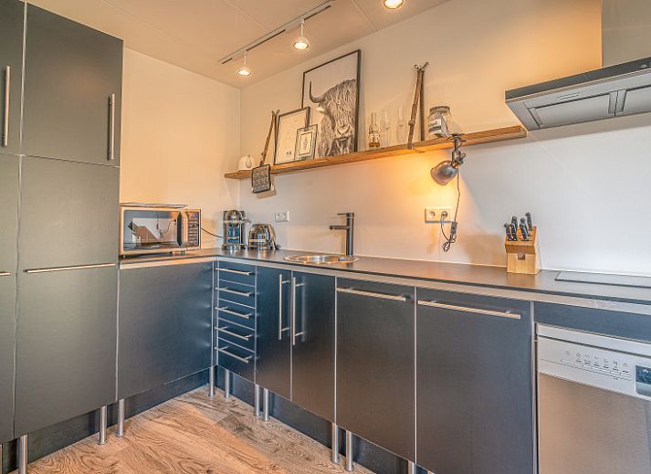 Gezellige woonkamer in Appartement Zee van Tijd, De Koog, Texel met comfortabele bank en natuurlijke lichtinval.