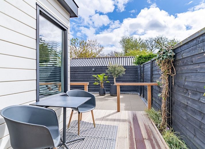 Gezellige woonkamer in Appartement Zee van Tijd, De Koog, Texel met comfortabele bank en natuurlijke lichtinval.