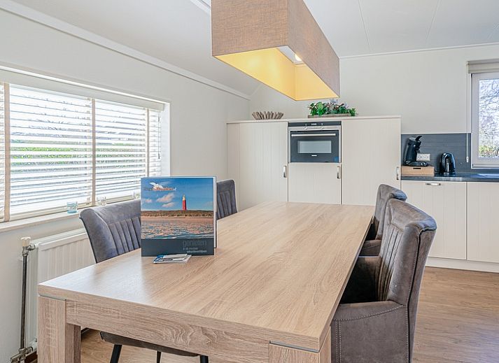 Cozy living room of Holiday home Honeysuckle 95 in De Koog, Texel with comfortable sofas and fireplace.