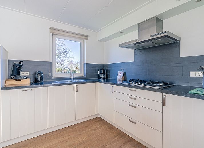 Cozy living room of Holiday home Honeysuckle 95 in De Koog, Texel with comfortable sofas and fireplace.